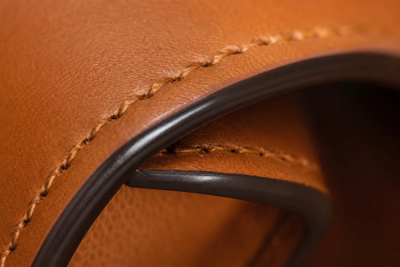 Extreme close-up of a premium finished leather bag edge with polished edge paint