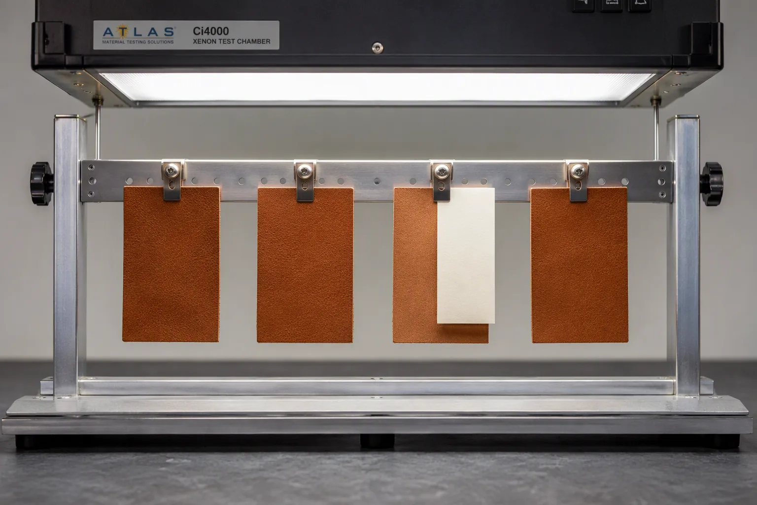 Leather swatches in a lightfastness test rack with one half masked